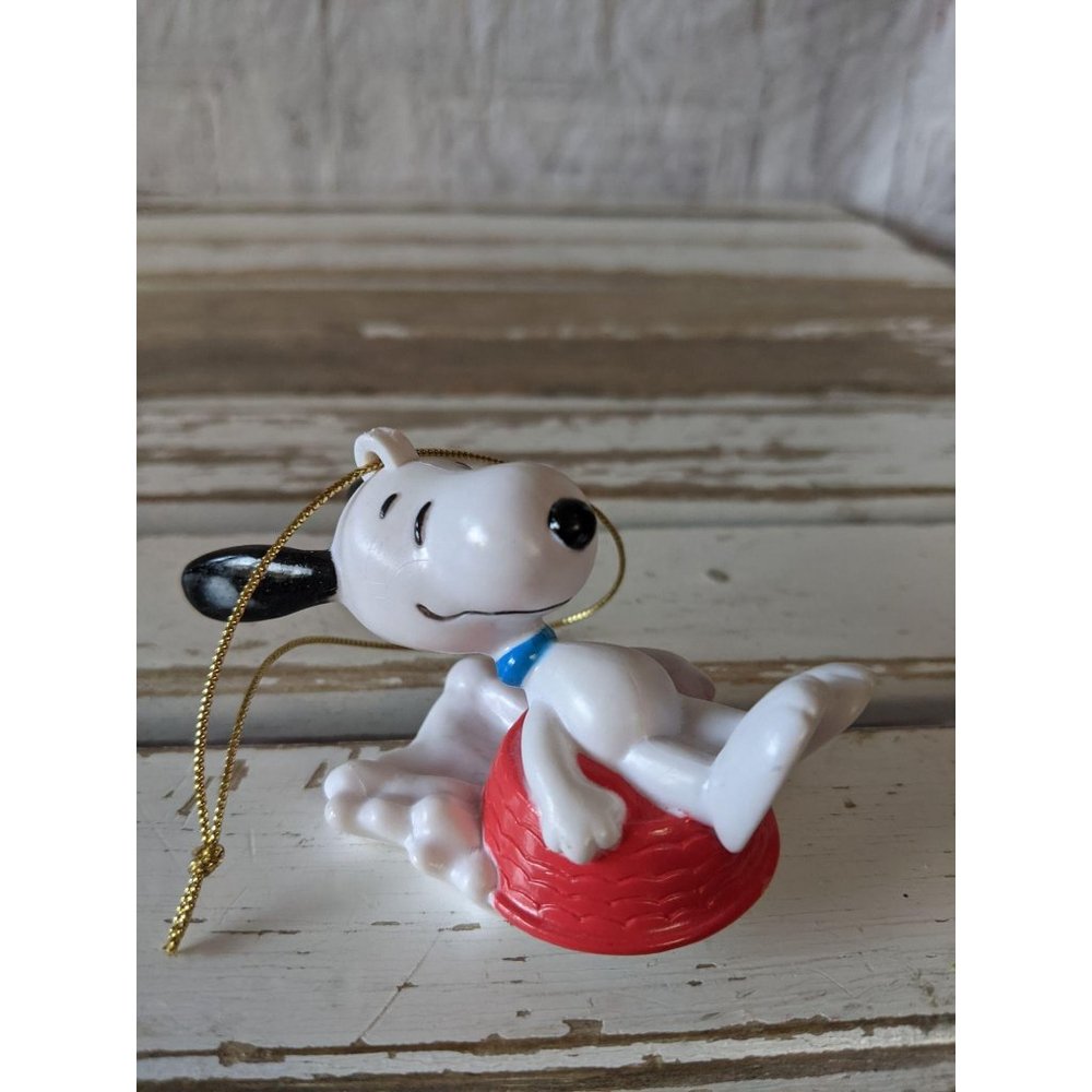 United features Snoopy dog bowl sledding ornament